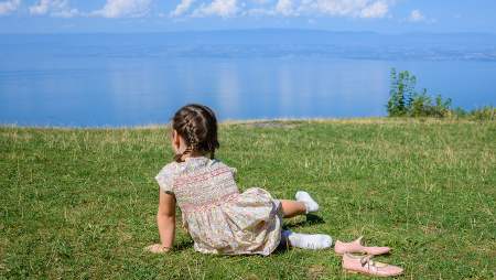 Hôtel Royal, 5 étoiles à Evian - Petite fille de dos face au lac Léman dans l'herbe