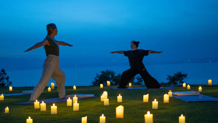 Hôtel Royal, 5 étoiles à Evian - Deux personnes en position de yoga face au lac léman avec bougies