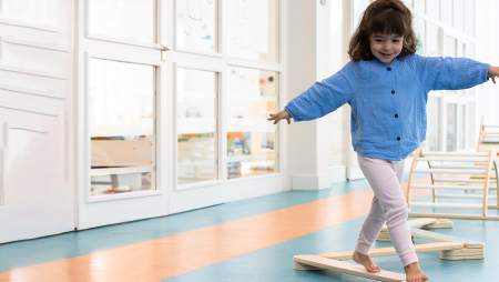 Evian Resort - Petite fille travaillant sa motricité sur des structures en bois au Kids Resort