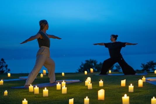 Hôtel Royal, 5 étoiles à Evian - Deux personnes en position de yoga face au lac léman avec bougies