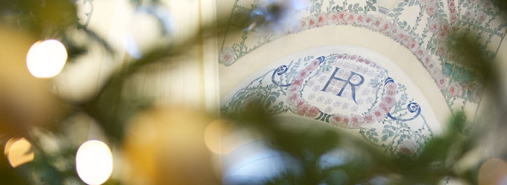 Plafond de l'Hôtel Royal avec le logo et les fresques avec un sapin de noël en premier plan