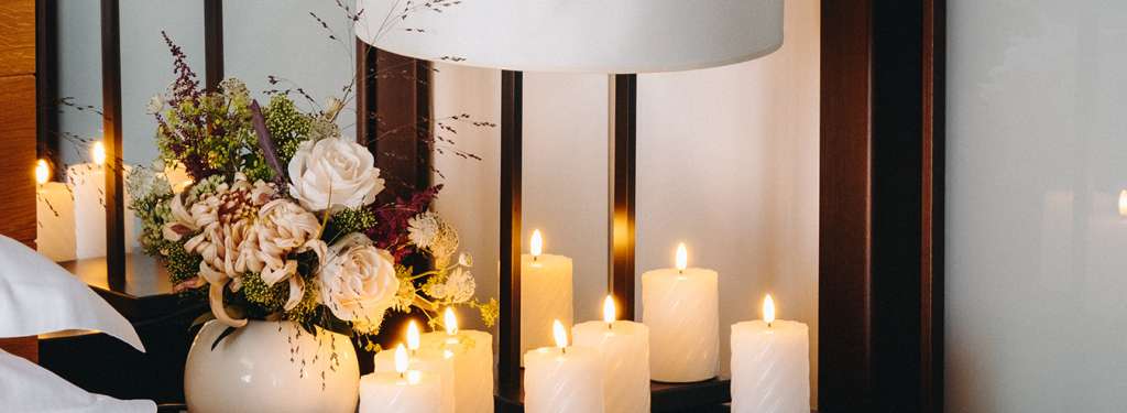 Hôtel Ermitage, 4 étoiles à Evian - Bougies, verre de champagne et bouquet de fleurs près du lit