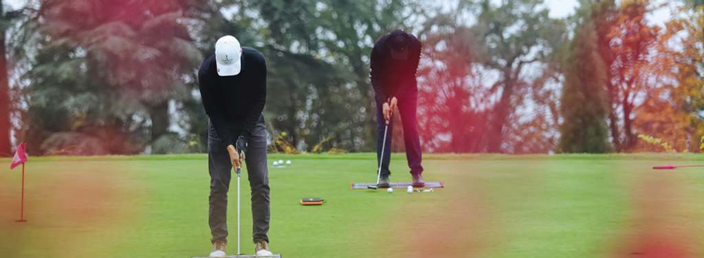 Evian Resort Golf Club à Evian - Deux Golfeurs en casquette se préparant à lancer