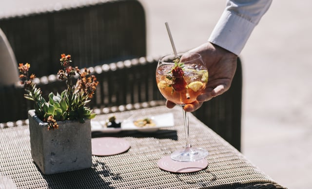 Un cocktail du bar La Chaise Longue, bar de piscine de l'Hôtel Ermitage, posé sur une table basse extérieur