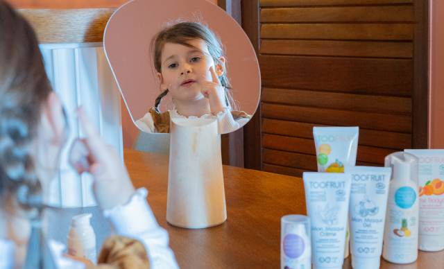 Hôtel Ermitage, 4 étoiles à Evian - Visage d'une petite fille dans le miroir se mettant de la crème Too Fruit lors d'Atelier à l'hôtel