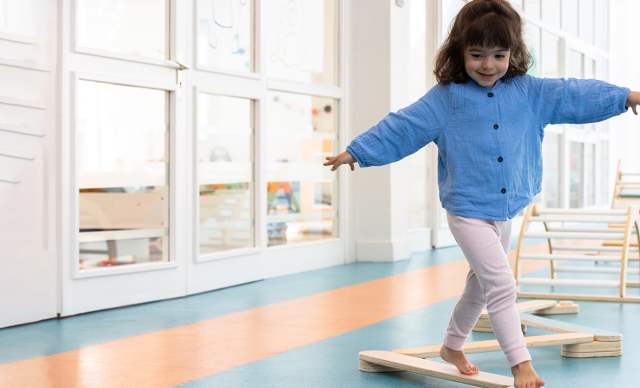 Evian Resort - Petite fille travaillant sa motricité sur des structures en bois au Kids Resort