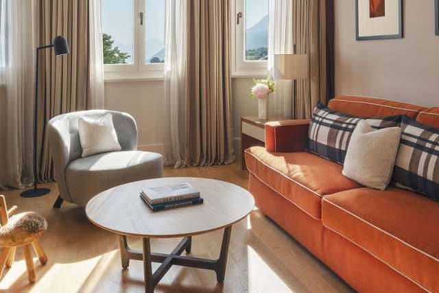 Hôtel Ermitage, 4 étoiles à Evian - Salon avec canapé orange et TV