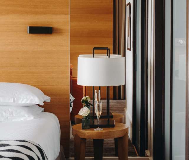 Hôtel Ermitage, 4 étoiles à Evian - Coin du lit avec une coupe et une fleur sur la table