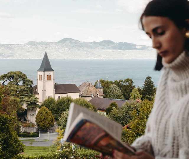 Femme lisant sur un balcon de l'hotel ermitage face au lac léman - Bloc content inversé layout droite _ gauche copie.jpg
