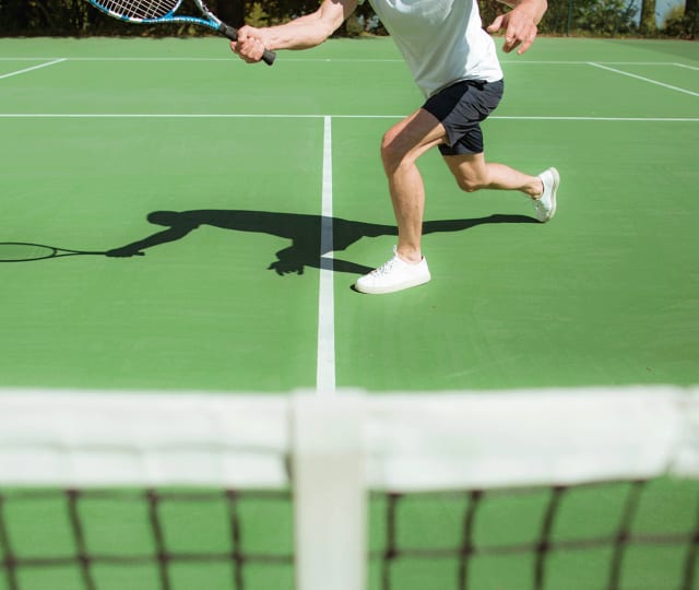 personne jouant au tennis à l'hôtel royal evian avec le membership tennis