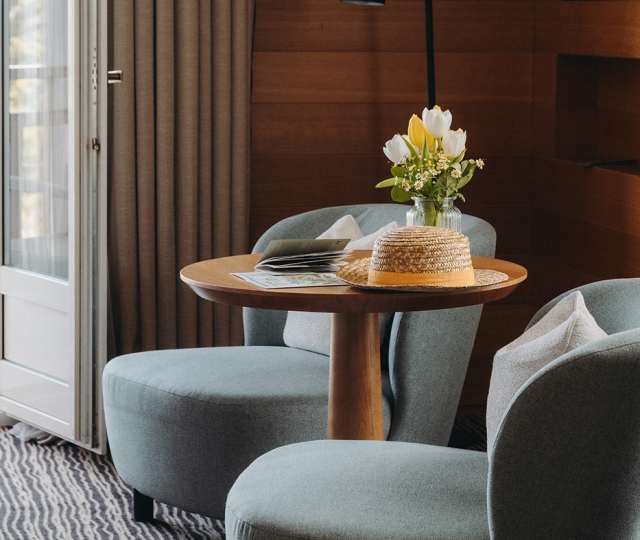 Hôtel Ermitage, 4 étoiles à Evian - Petit salon d'une chambre de l'hôtel avec des fleurs