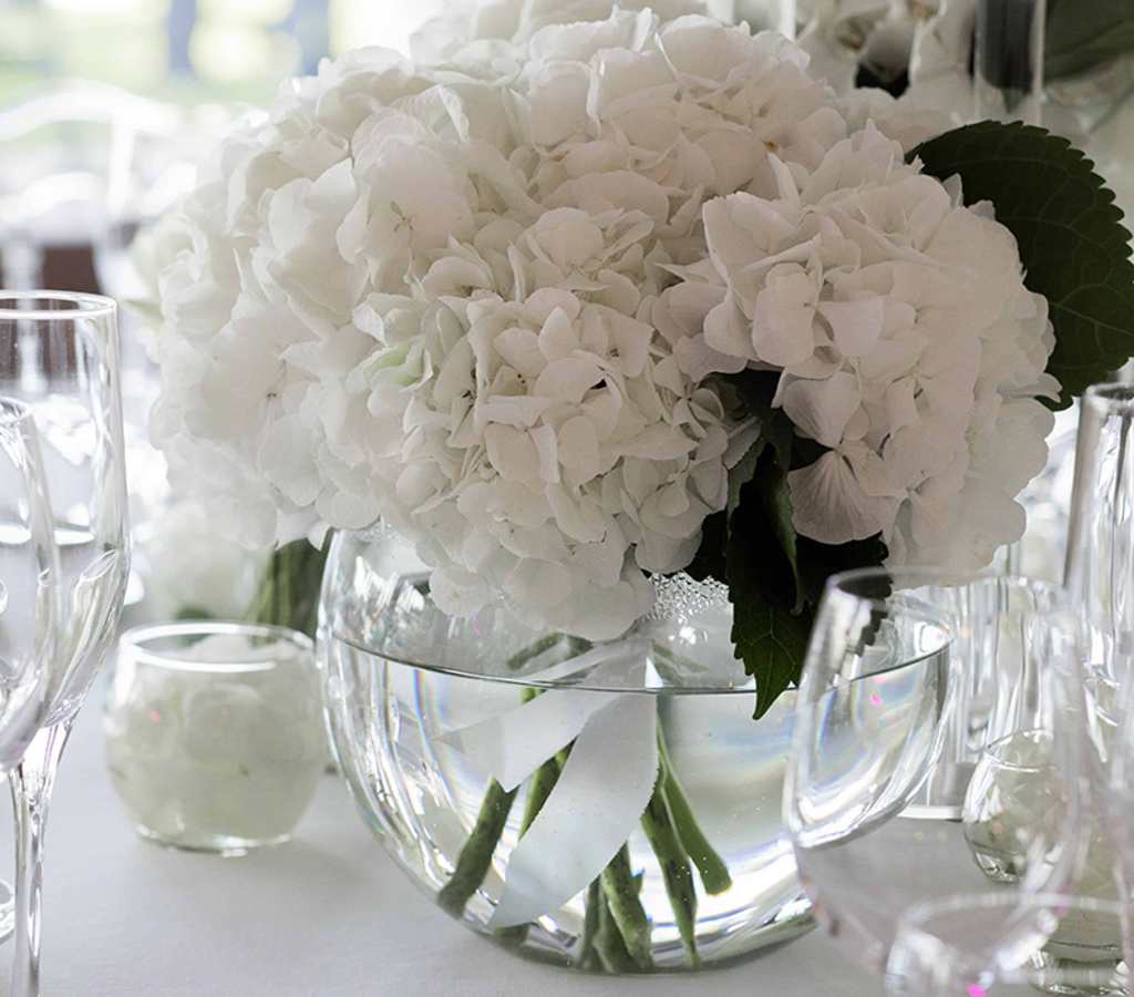 Table pour un mariage à l'Hôtel Royal avec de grosses fleurs blanches dans un vase rond