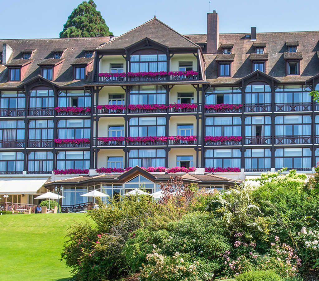 Façade de l'Hôtel Ermitage en été vue depuis le parc