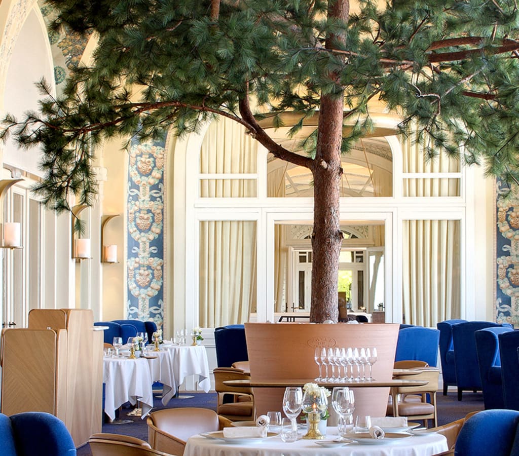 Salle du restaurant Les Fresques à l'hôtel royal, avec les fresques de Jaulmes au plafond et son arbre iconique