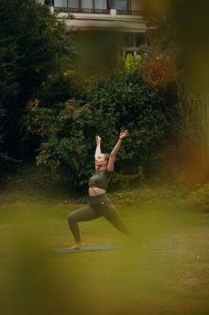 Femme dans le parc en position de Yoga, l'hôtel Ermitage en arrière plan