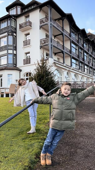 une fille et un garçon en doudoune devant l'hôtel Ermitage jouant