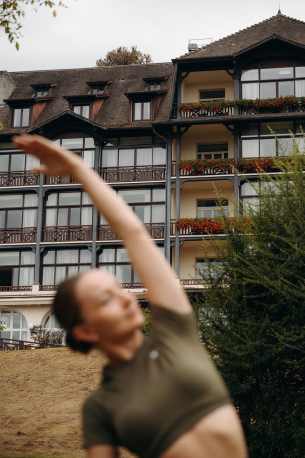 Femme floutée au premier plan et façade de l'hôtel Ermitage à l'arrière