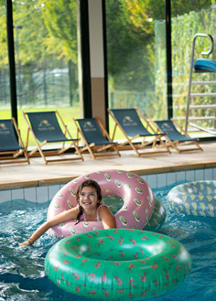 Une jeune fille qui joue dans la piscine chauffée du Kid's Resort avec des bouées gonflables