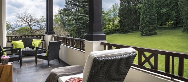 Balcon de la Chambre Privilège Sud avec transat et coin salon. Le tout avec vue sur le parc