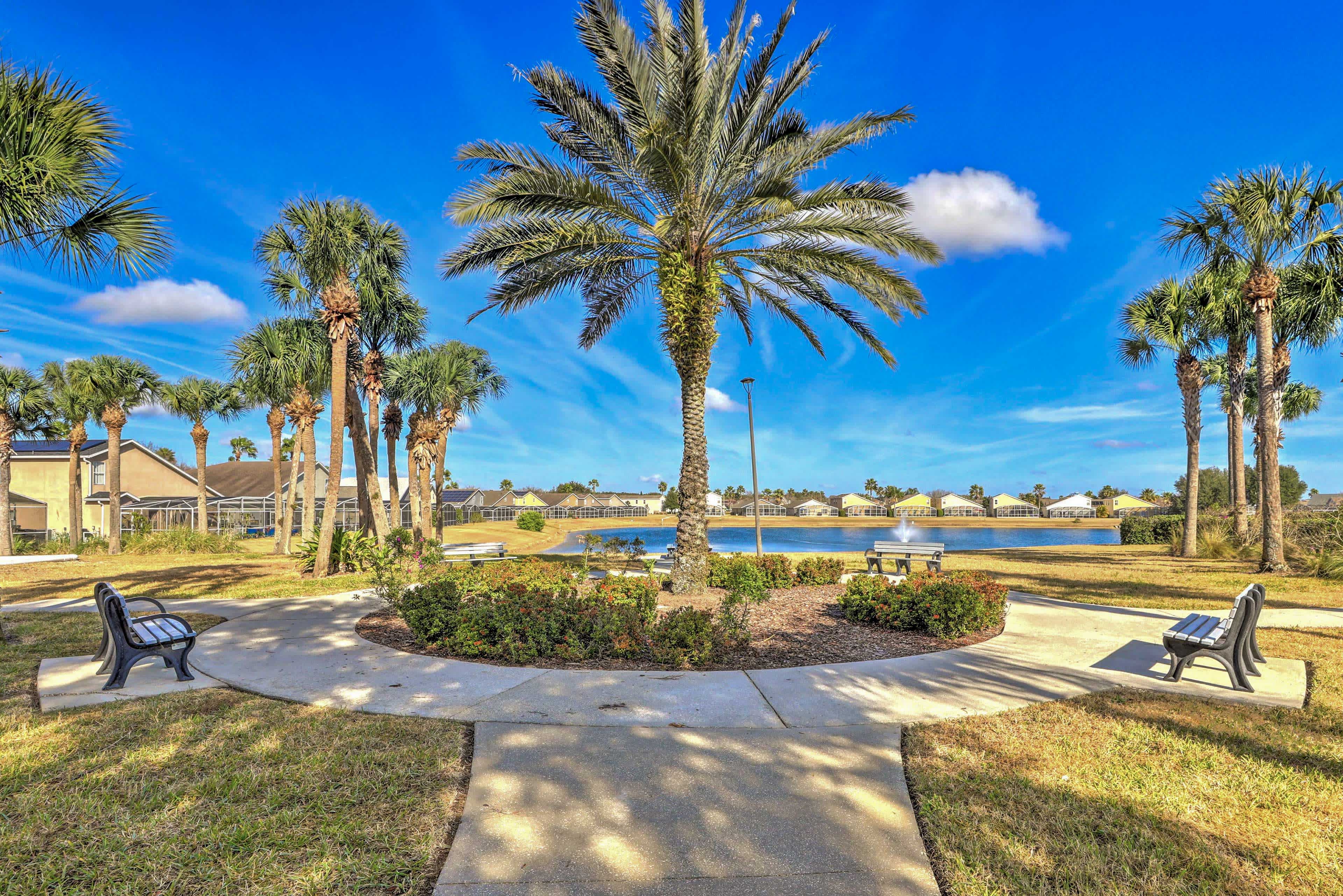 Suburban park in Davenport, FL with benches and palm trees and a small pond surrounded by houses in the background