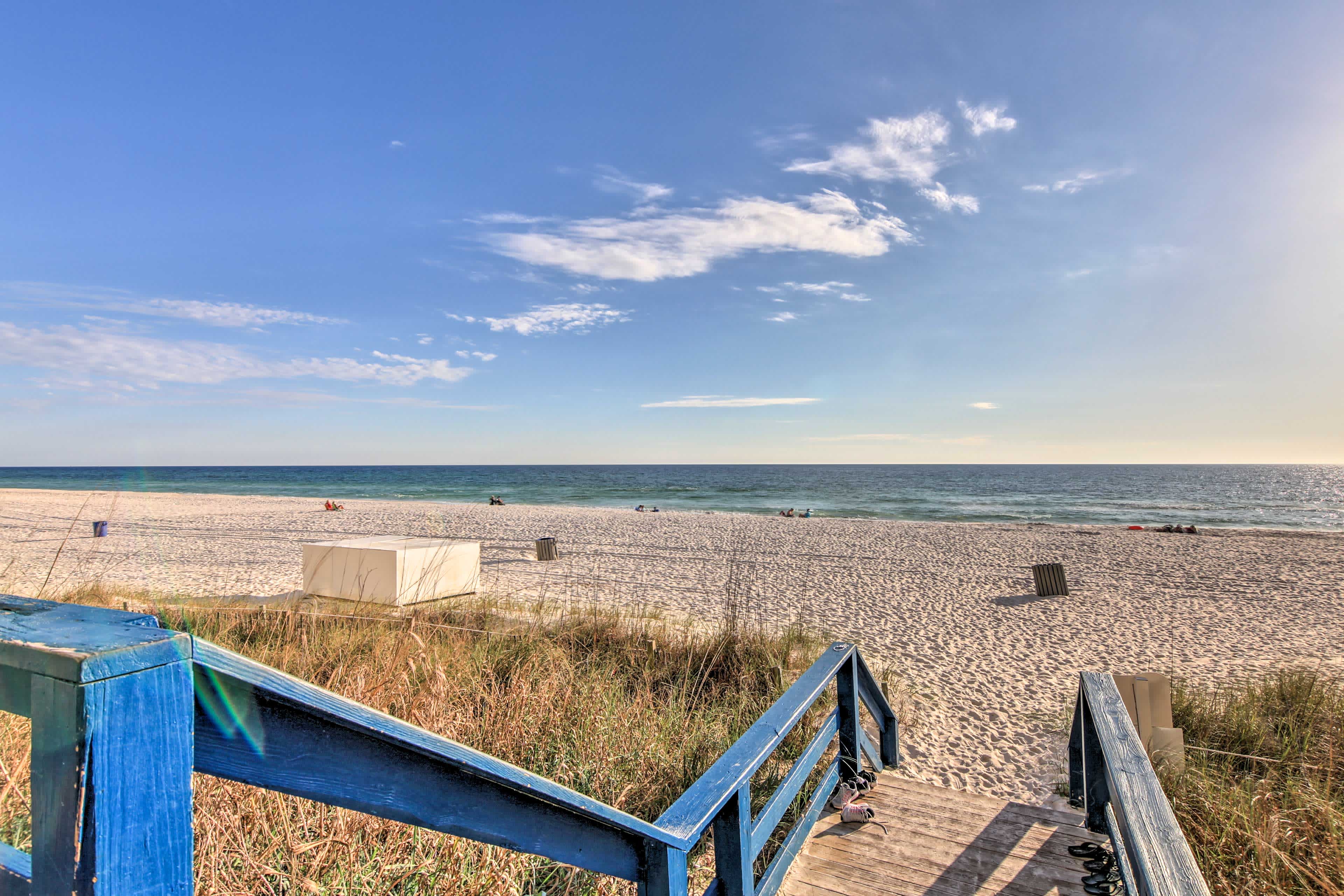 Beach view in Panama City Beach, FL with a wooden walkway leading to a sandy beach and ocean view