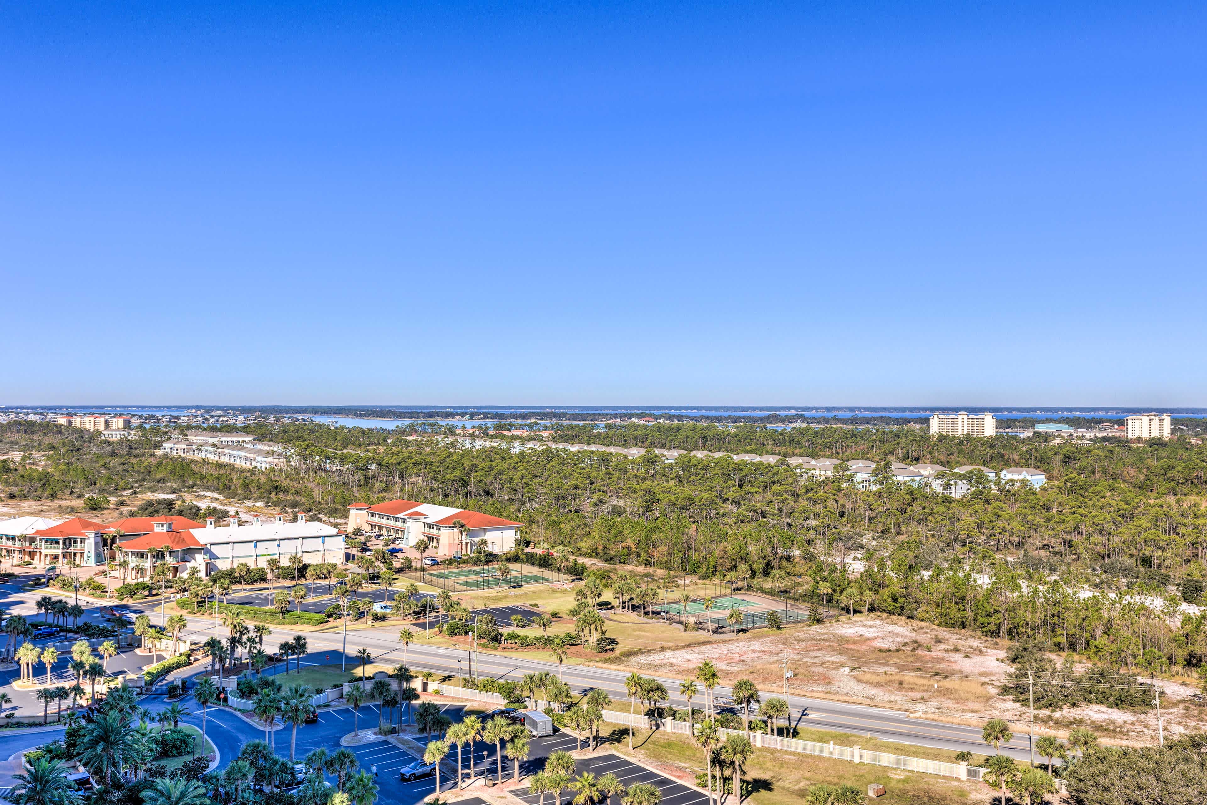 View from a balcony overlooking Pensacola, FL trees with water in the background