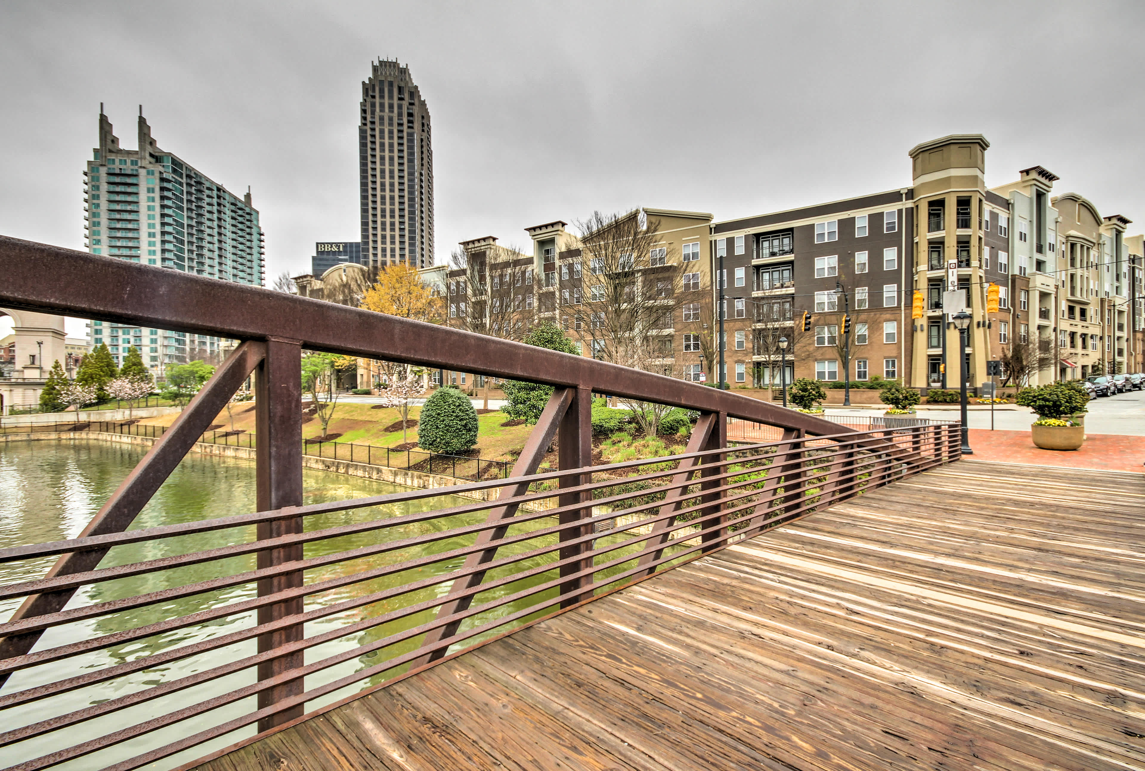 View of a wooden bridge over a river with downtown Atlanta, GA buildings in the background