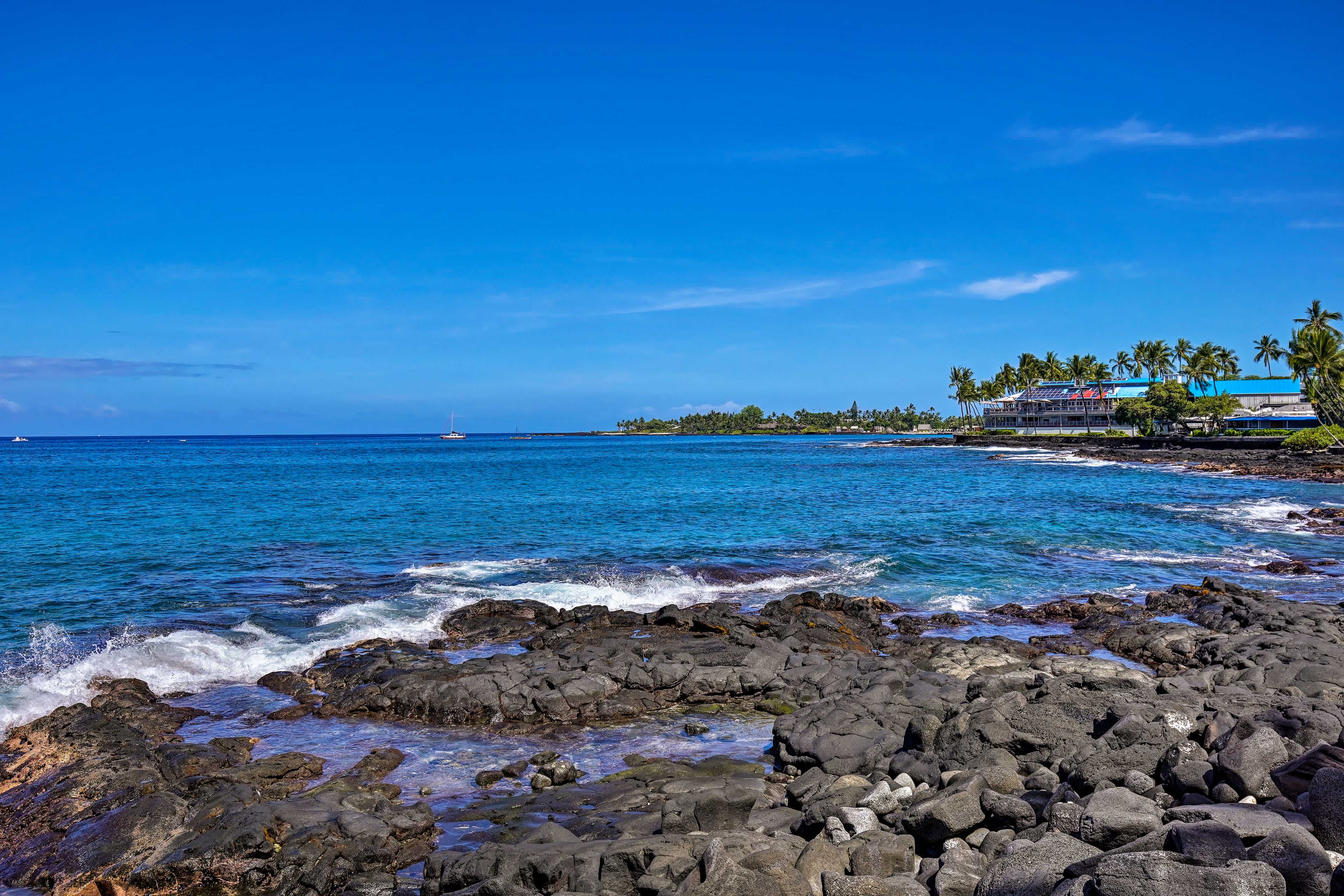 Rocky shore in Kailua-Kona, HI with blue water and blue skies