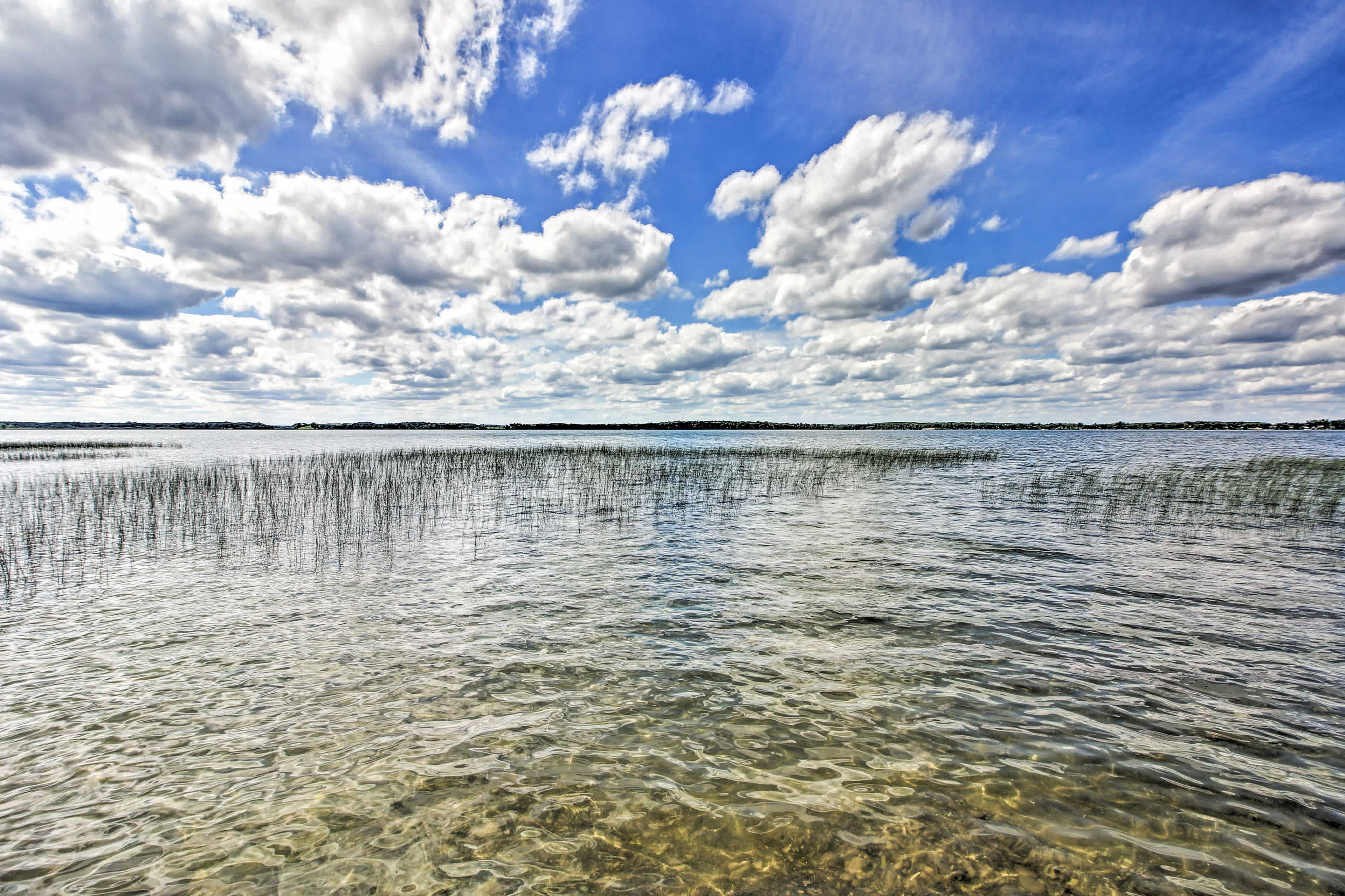 View of a big lake in Dent, MN with blue cloudy skies above