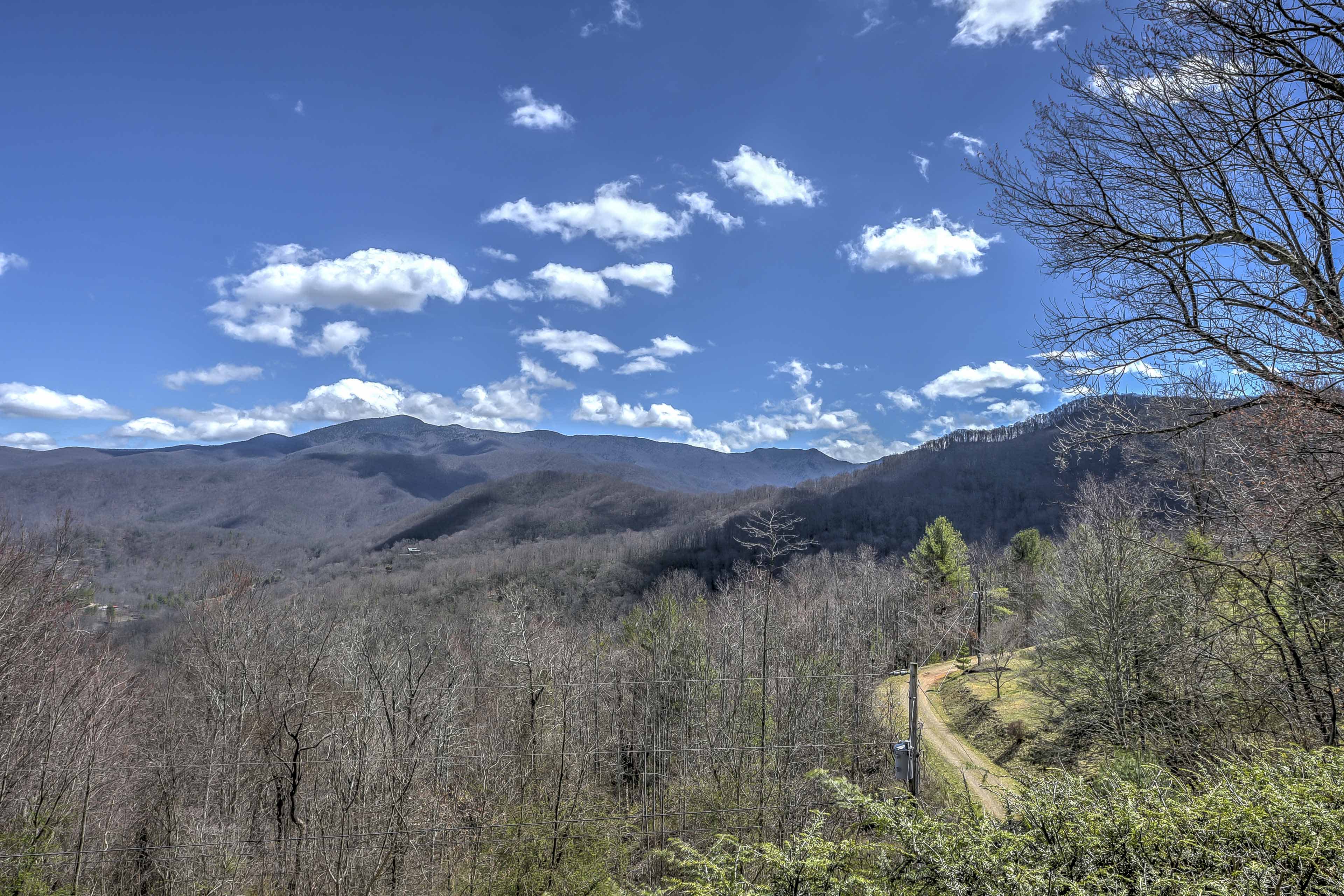 Aerial view of tree-covered mountains and a winding dirt road in Burnsville, NC