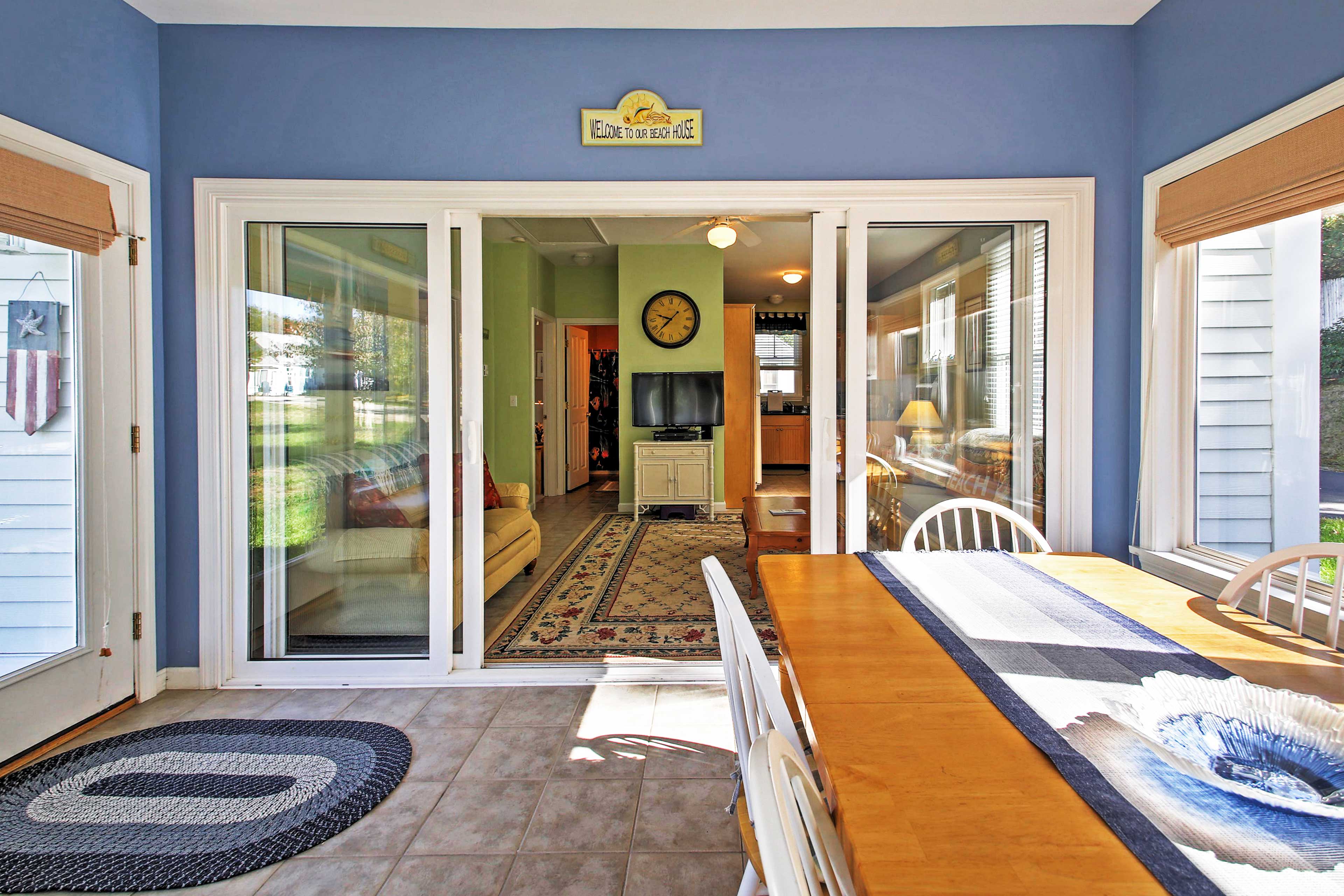 Double sliding glass doors connect the sun room to the rest of the cottage.