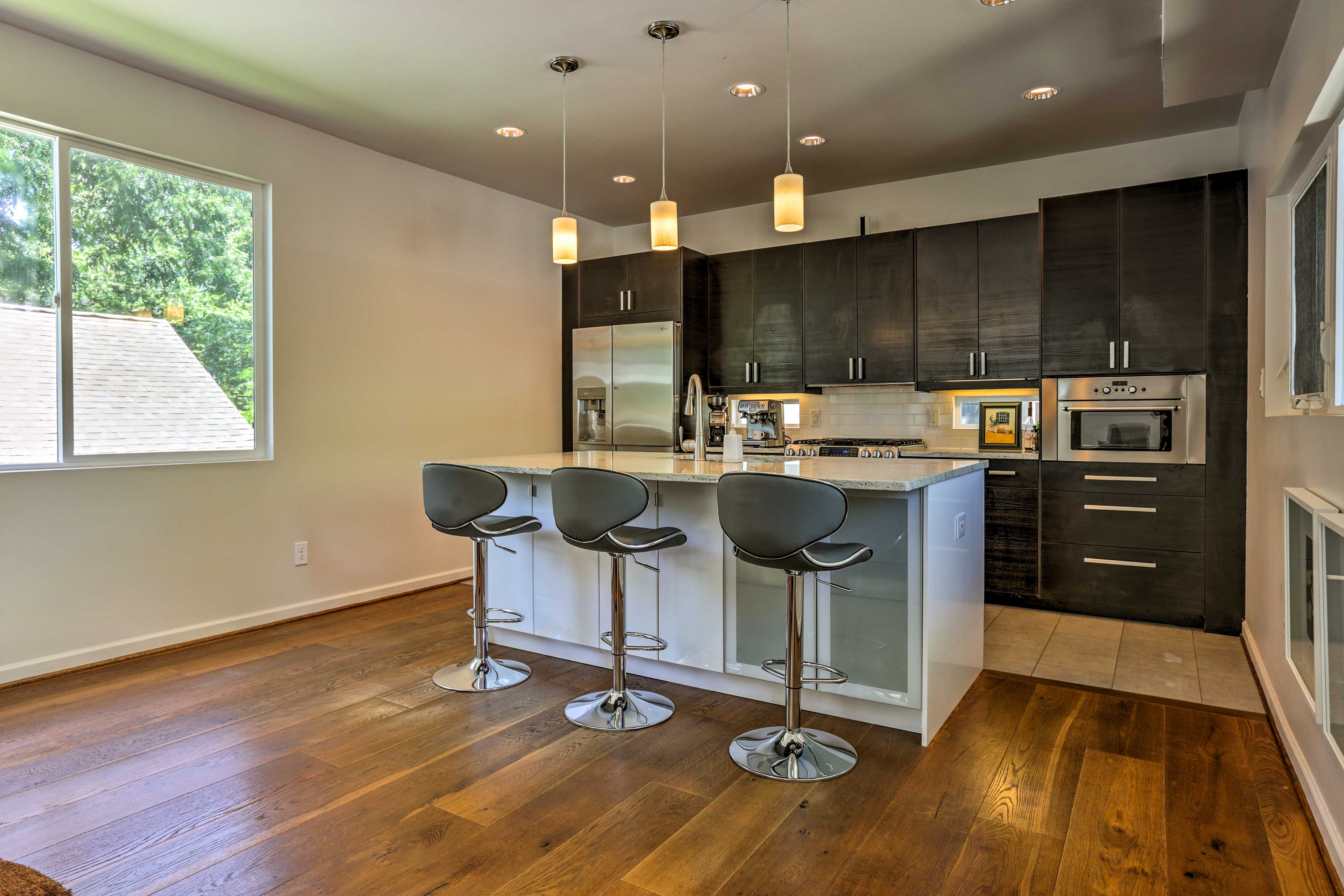 The space features top-of-the-line appliances and a sleek dining bar.