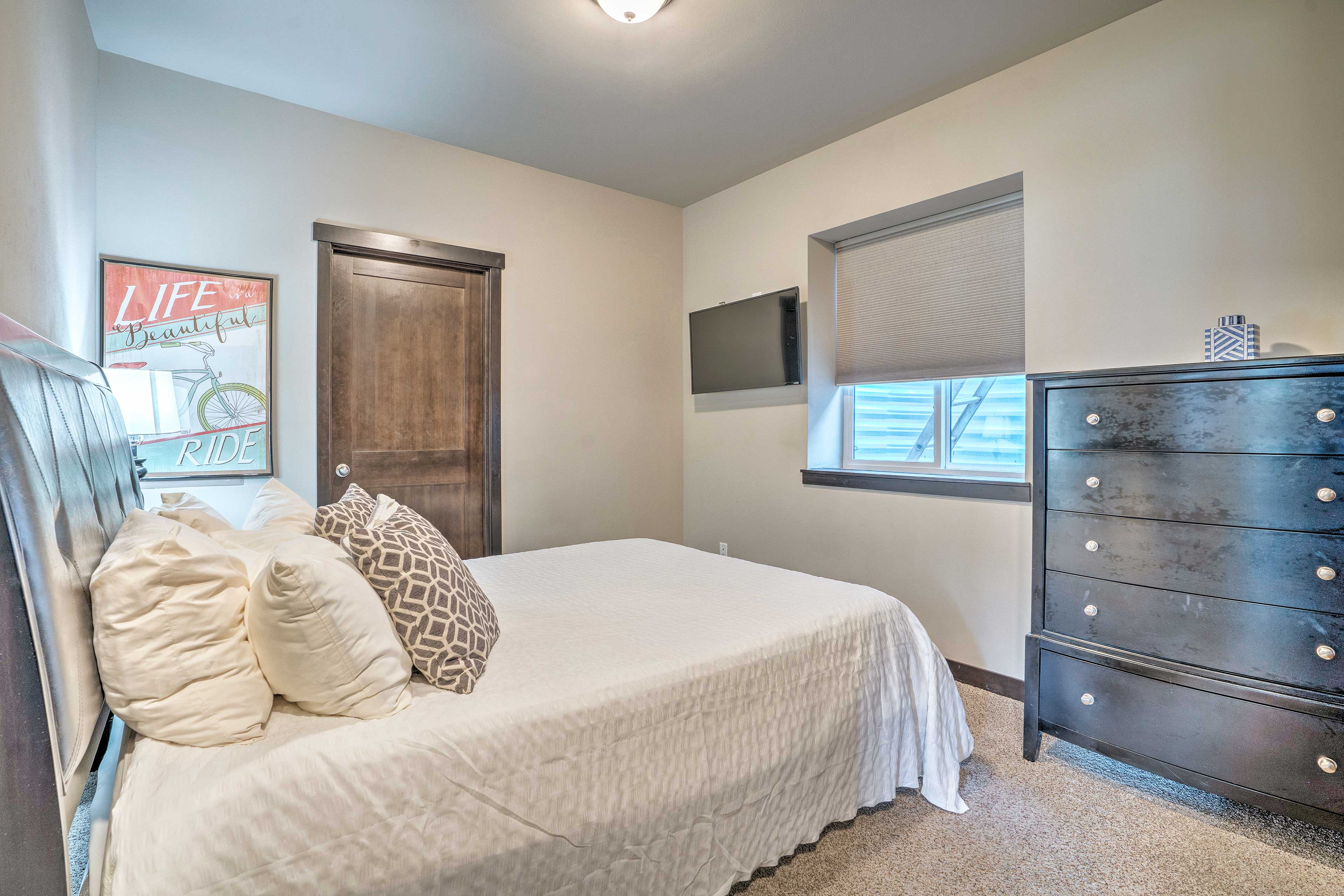 The first bedroom provides a queen bed and flat-screen TV.