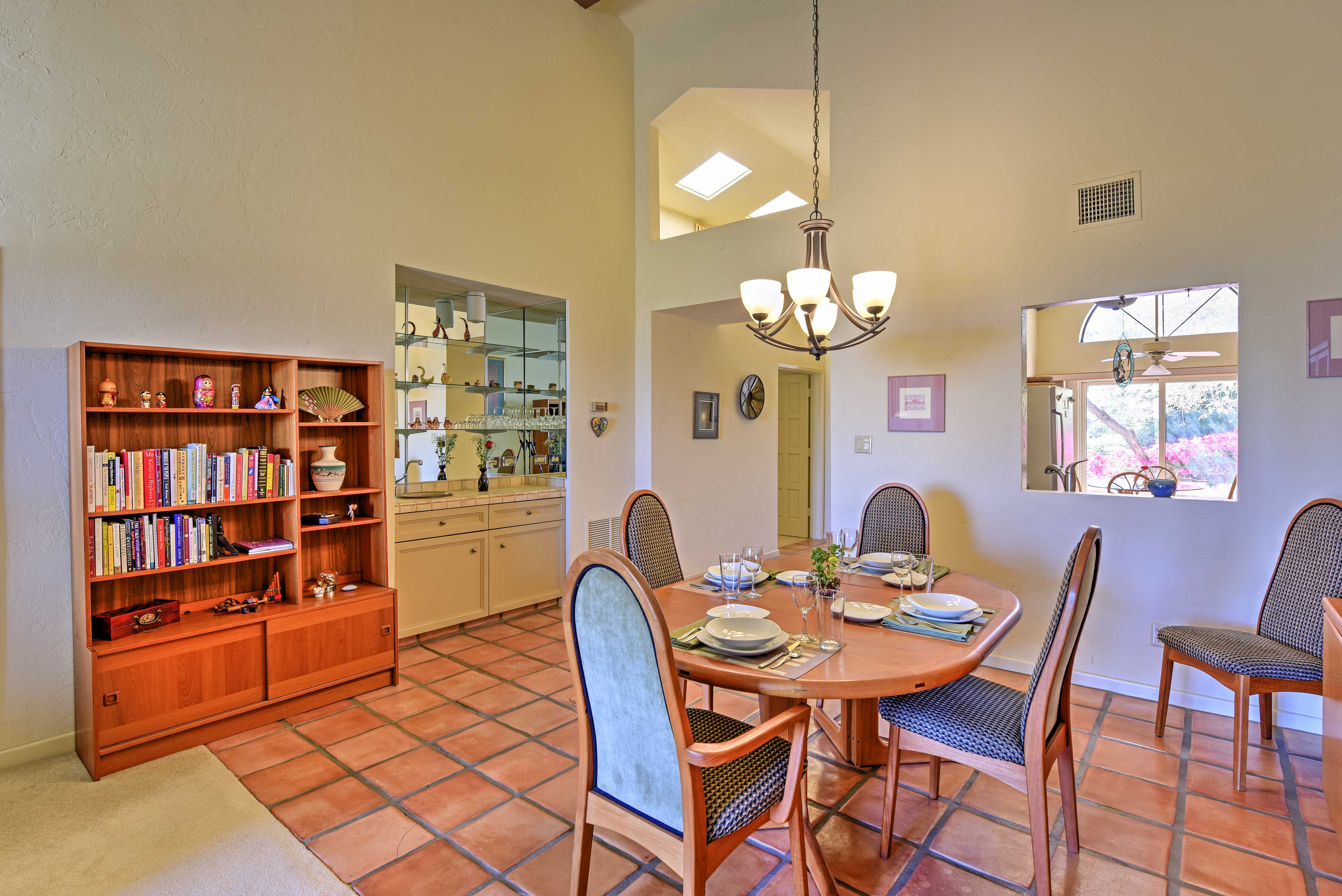 You can still socialize with your traveling companions from the kitchen through the opening in the wall while they enjoy their meal at the dining room table set for 4.