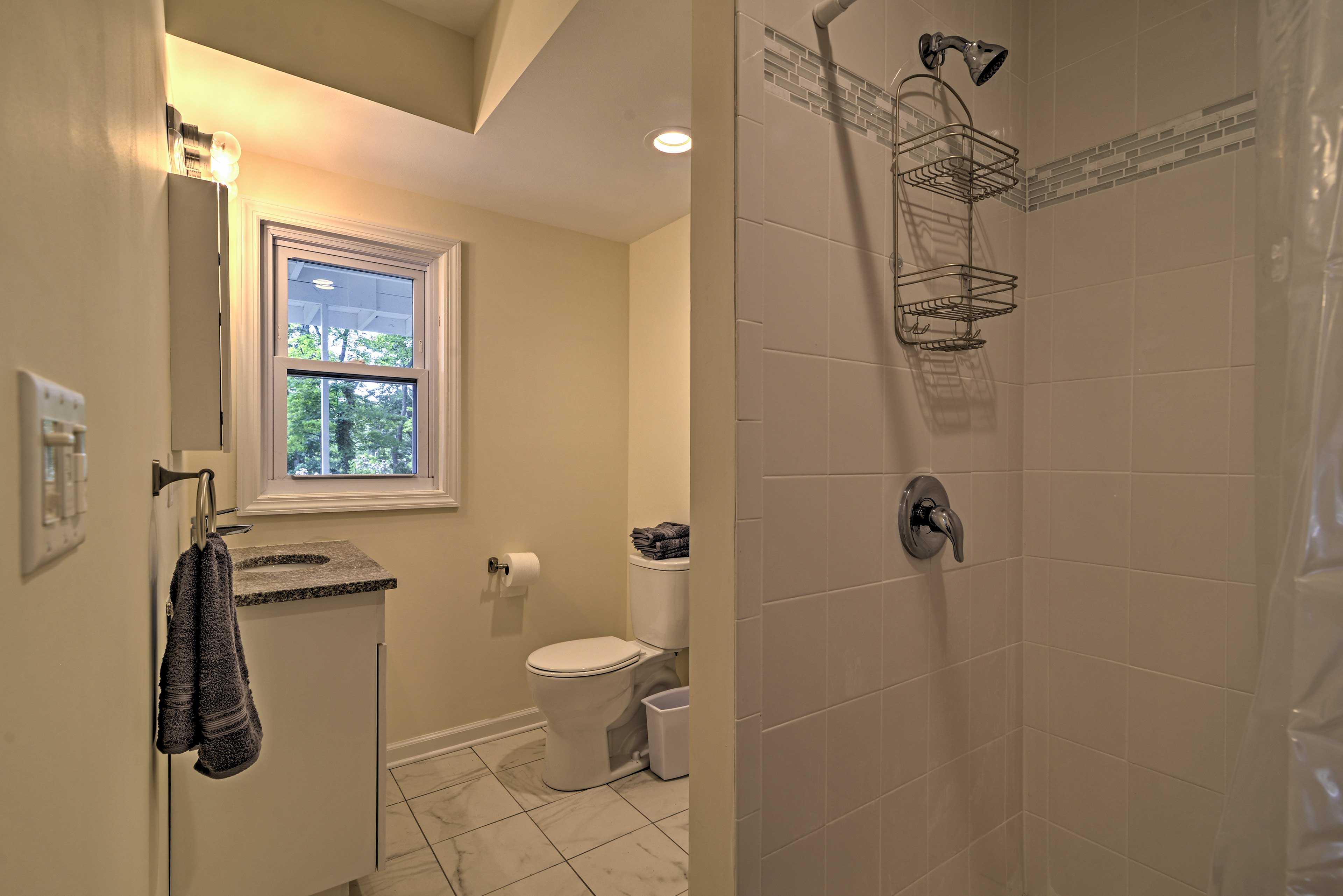 This full bathroom comes complete with a vanity and tiled walk-in shower.