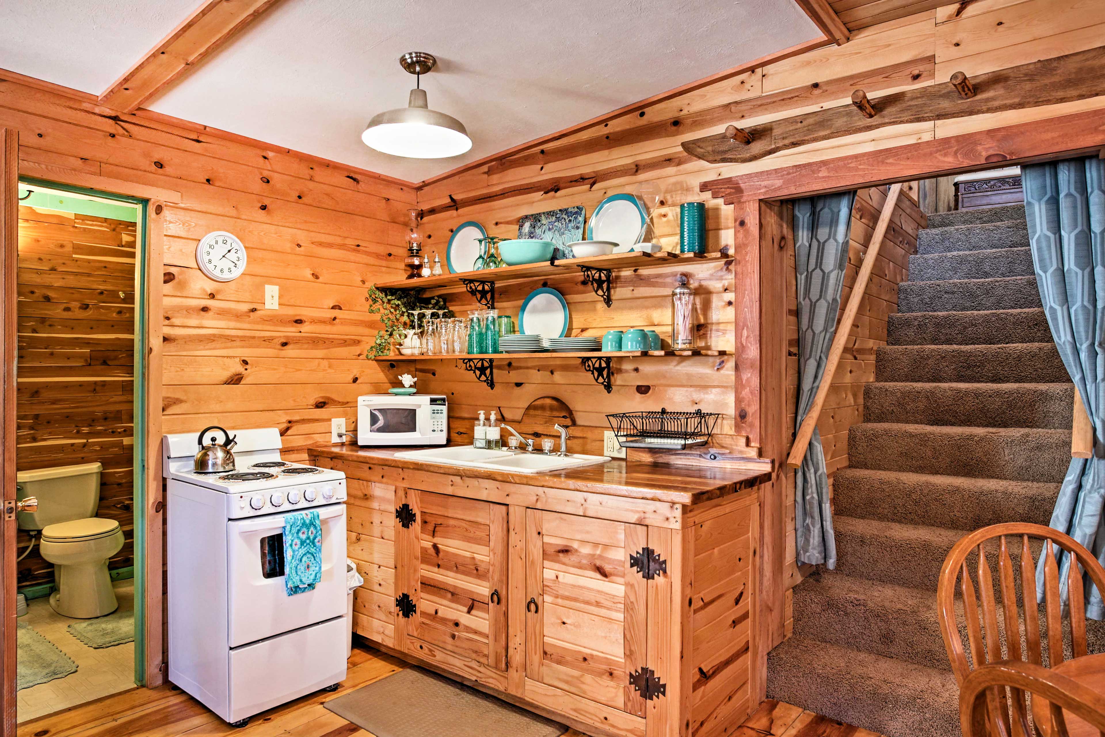 The kitchenette has a fridge, microwave, a stove and plenty of culinary tools.