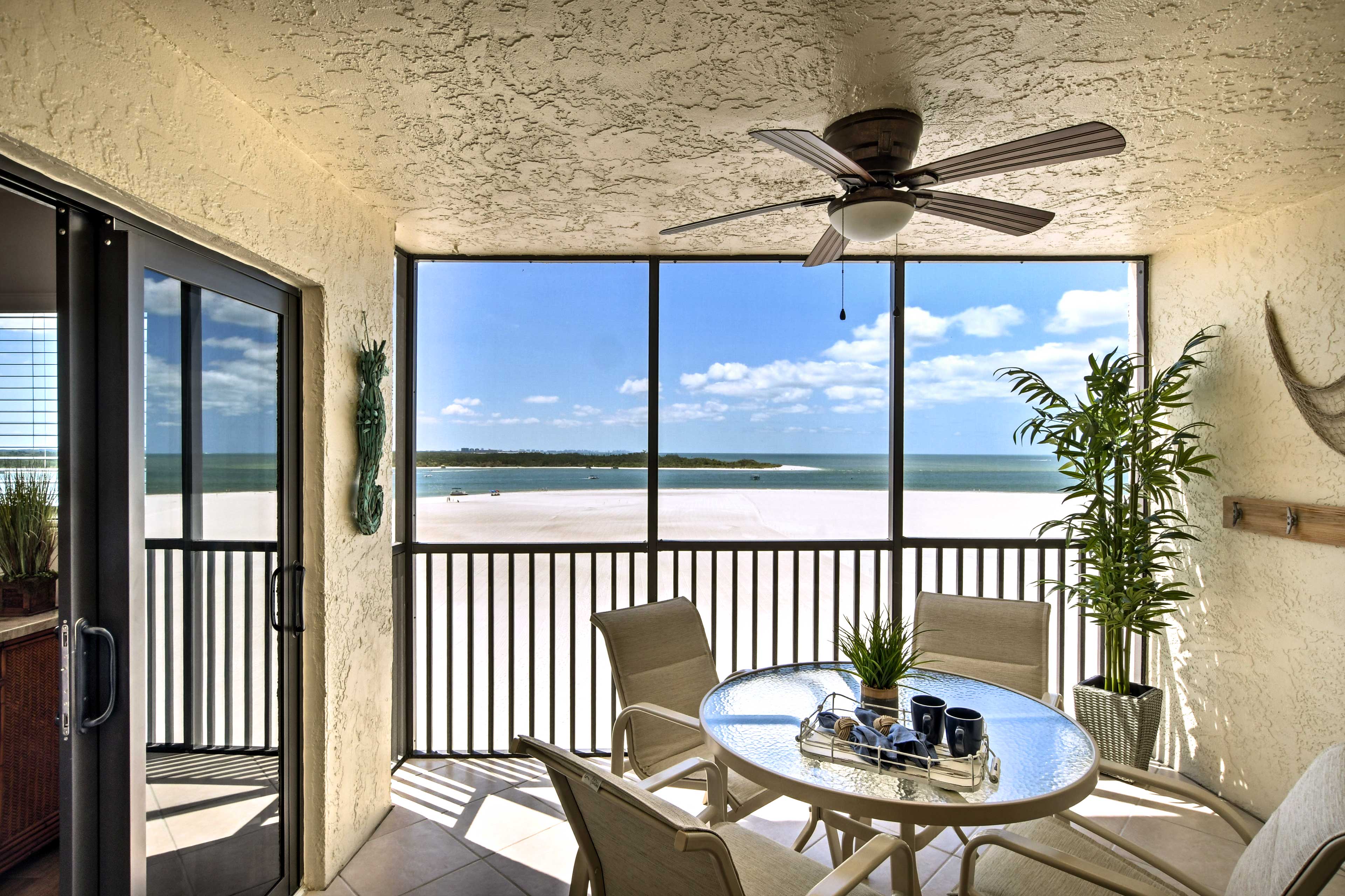 The screened-in porch has a 4-person table for dining beside serene beach views.