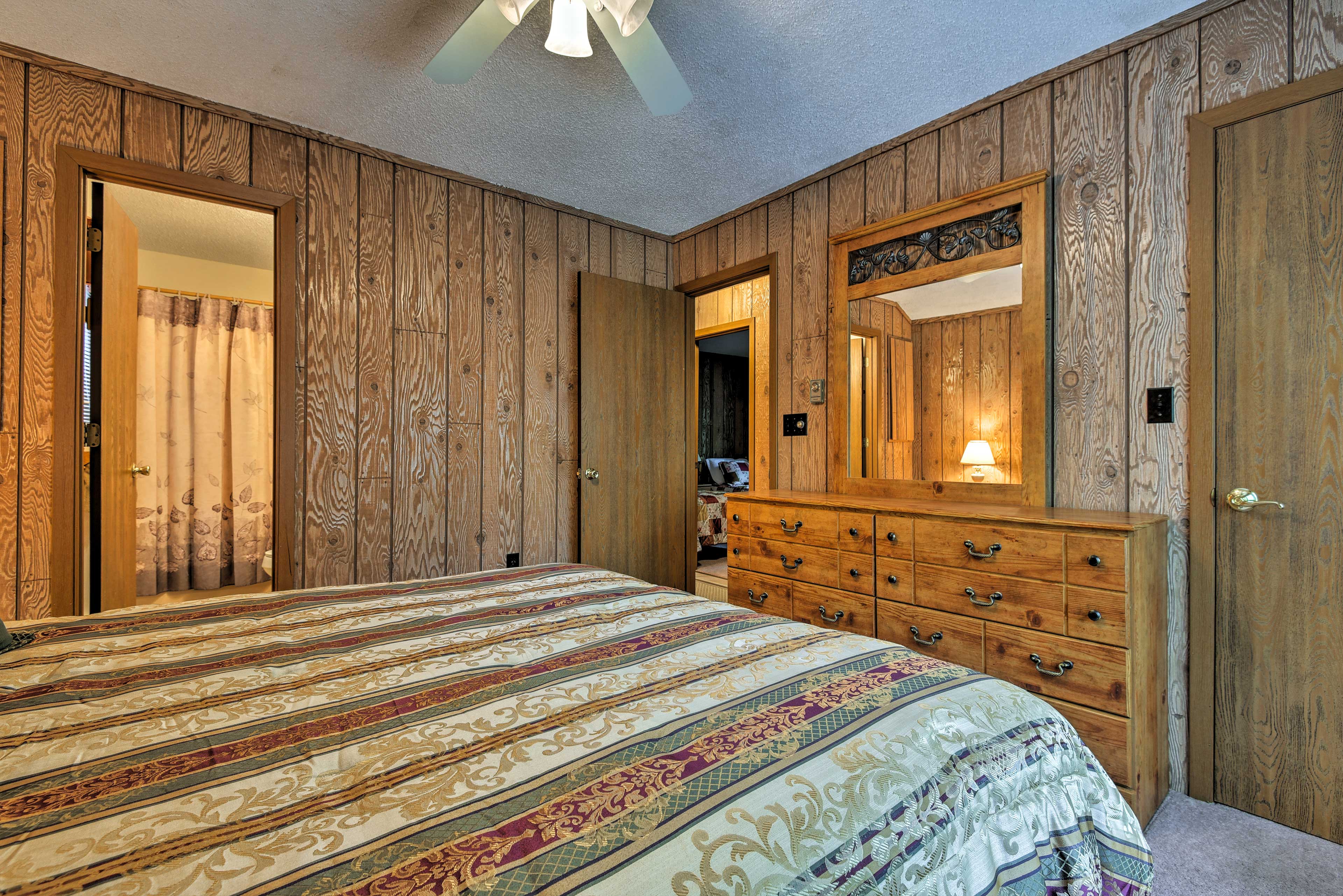 The first bedroom features a spacious dresser for unpacking & a private bath .