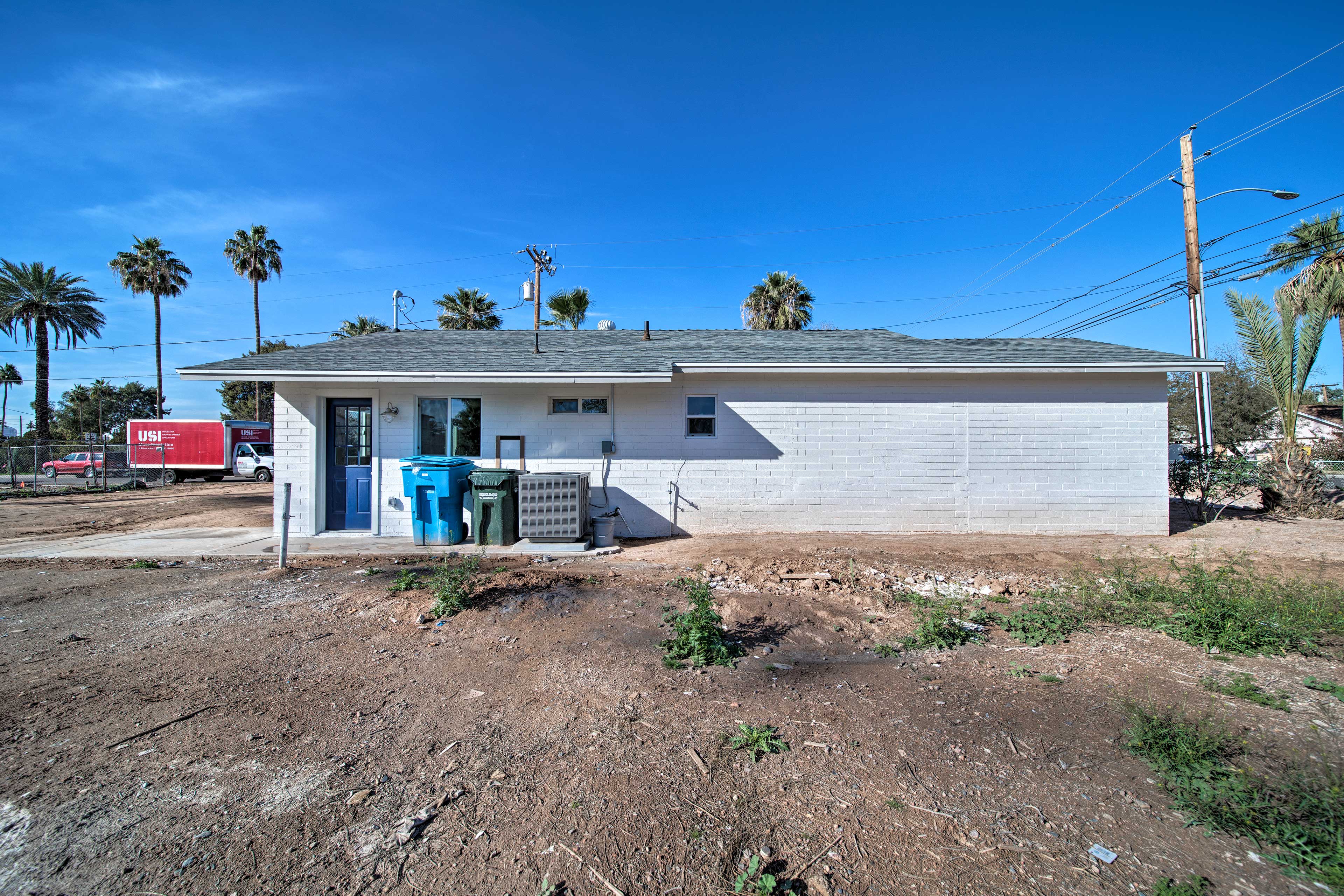 There is a large yard ideal surrounded by palm trees.