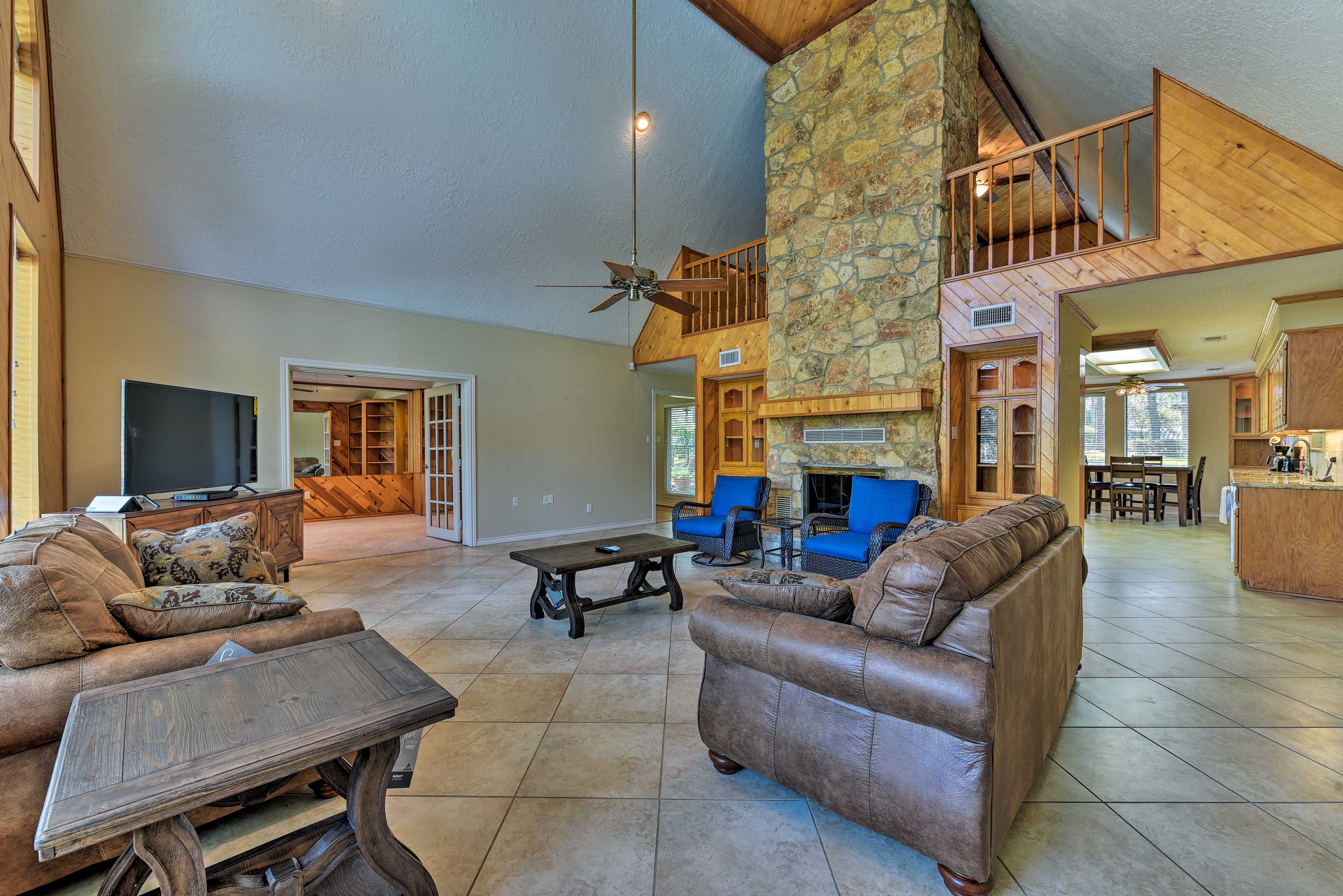 The 2-story stone fireplace accents the massive flat-screen cable TV.