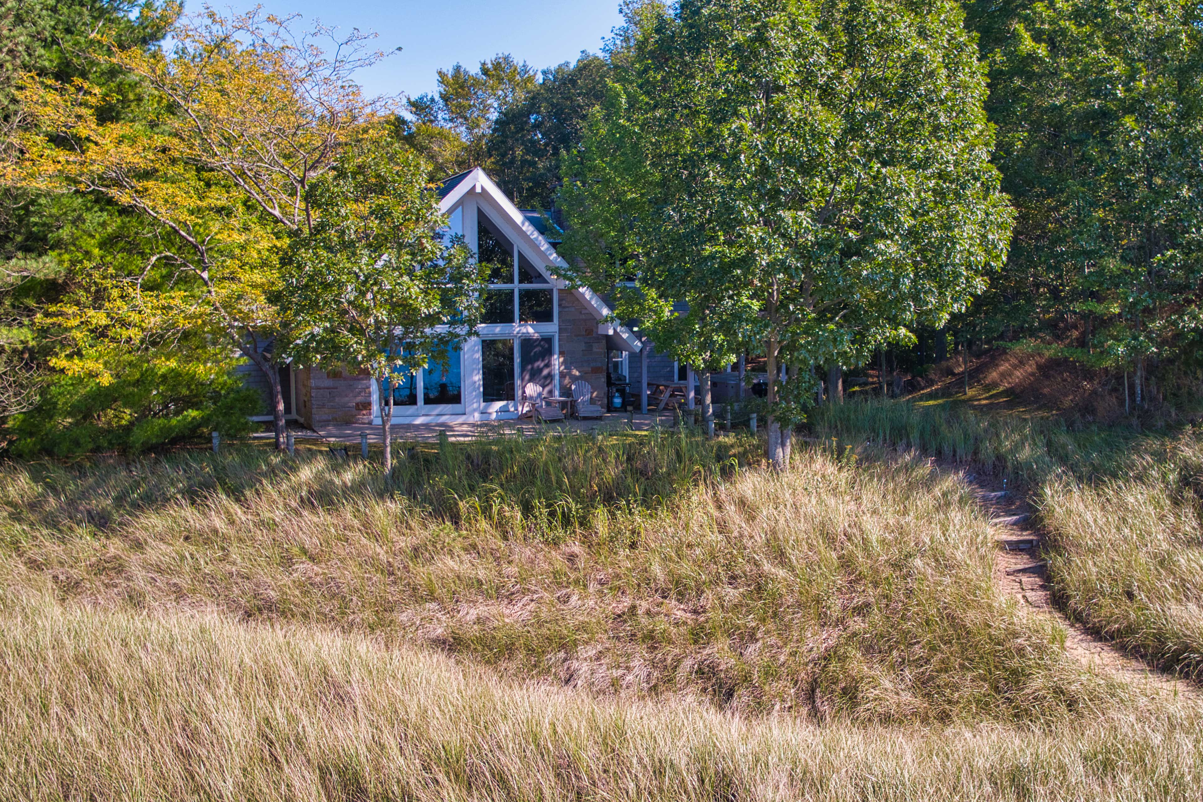 Beautiful foliage, grass, and trees surround this property.