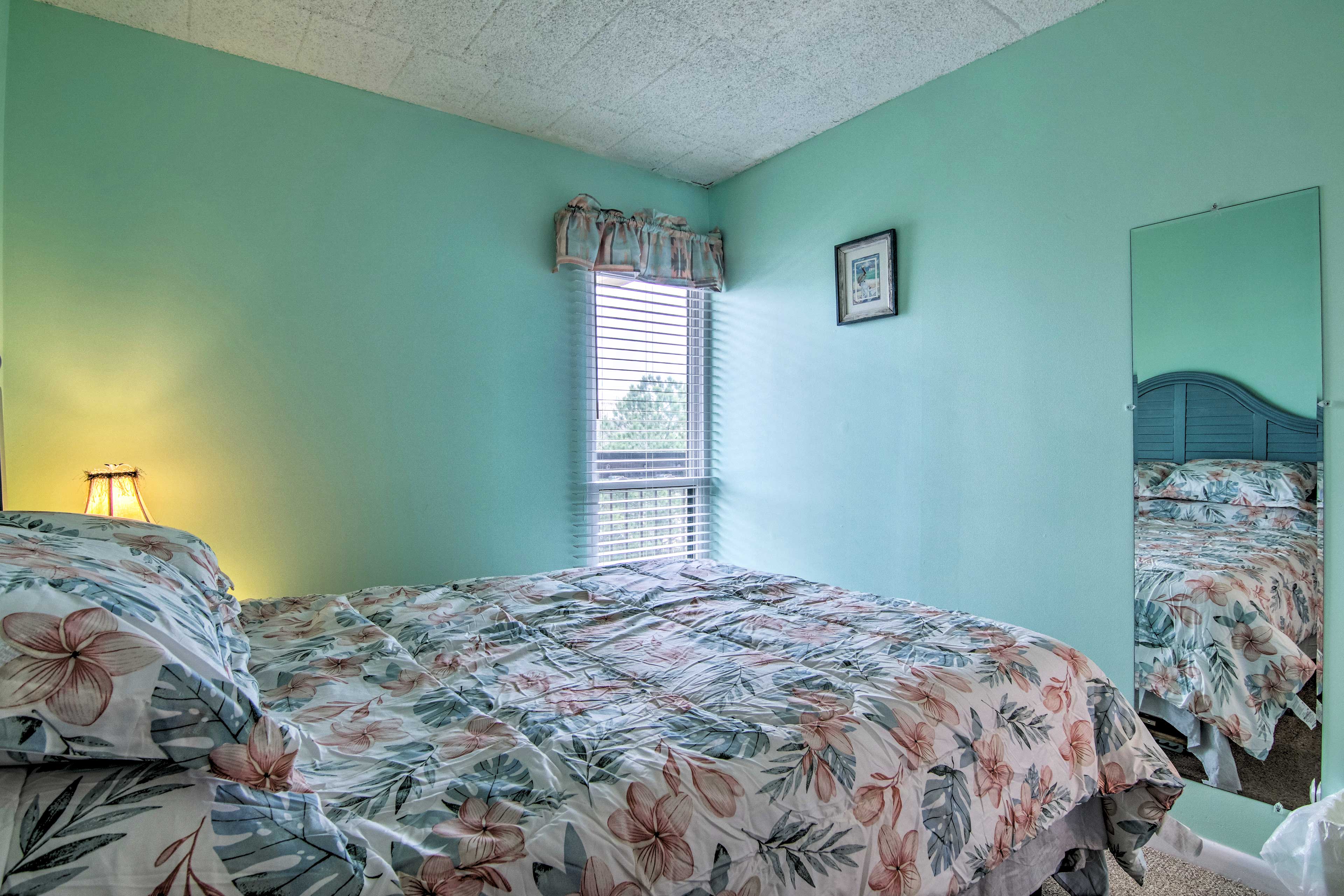 The second bedroom has a queen bed and coastal-style bedding.