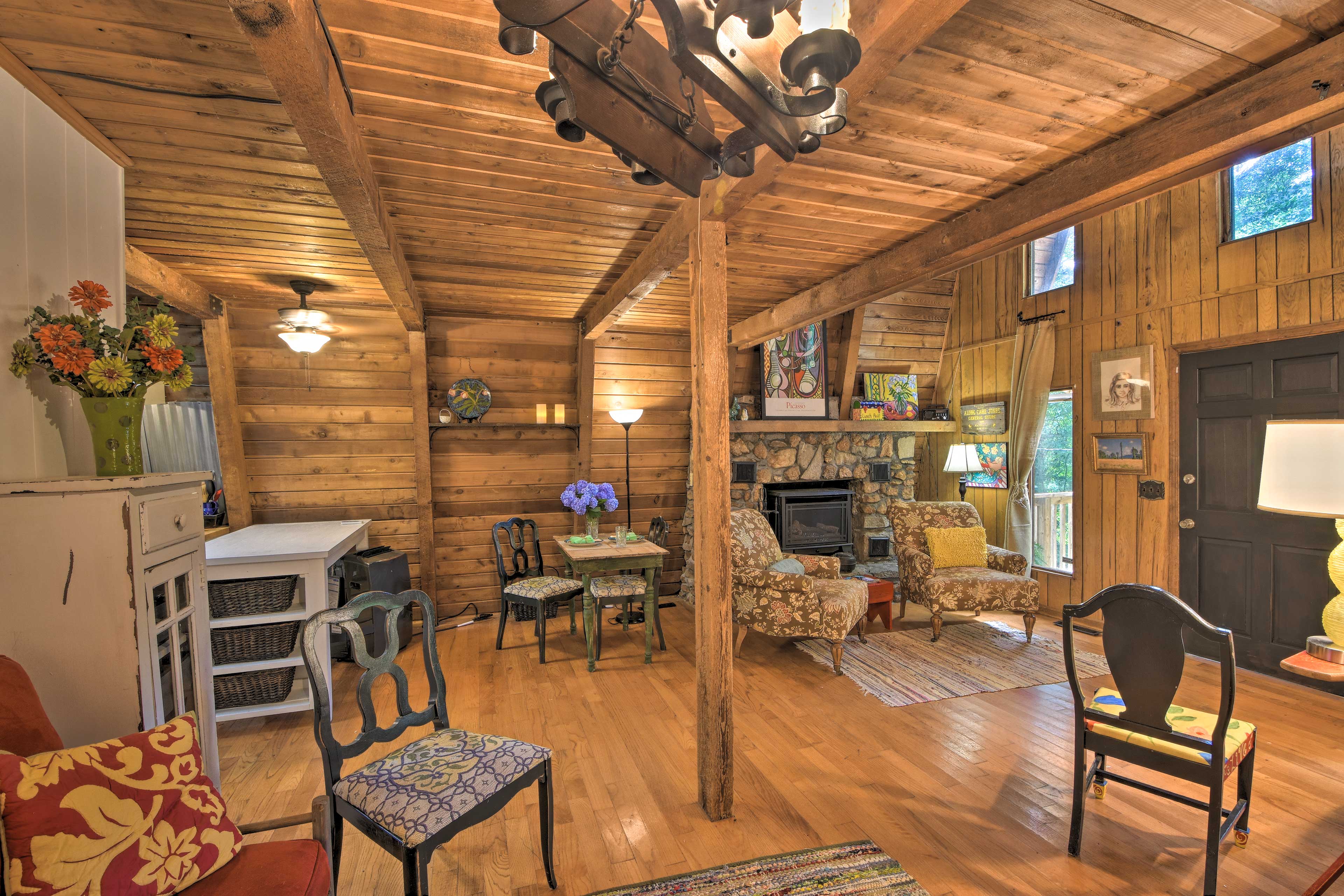 Cozy in by the fire featuring a rustic stone mantel.