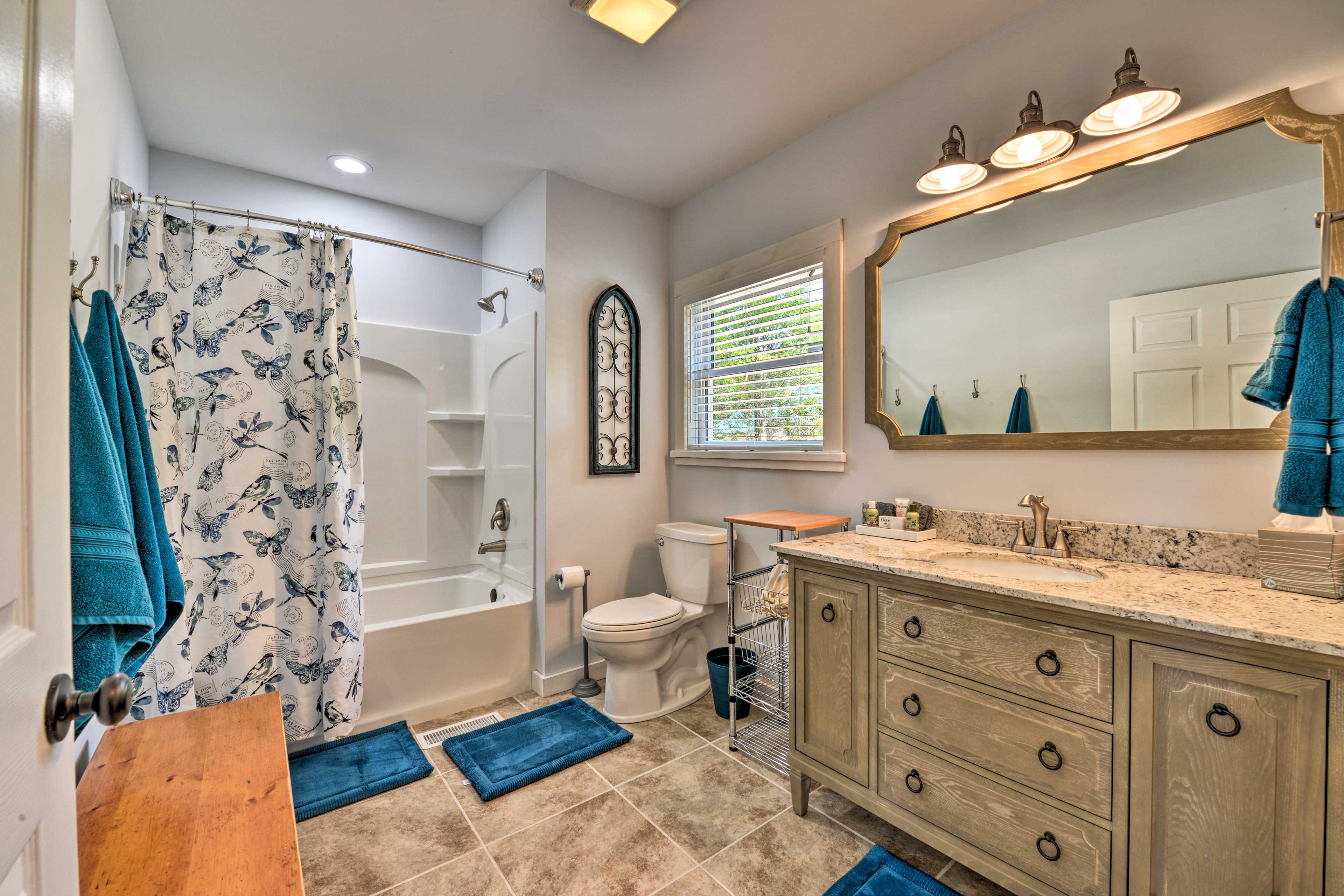 This spacious full bathroom hosts a shower/tub combo.