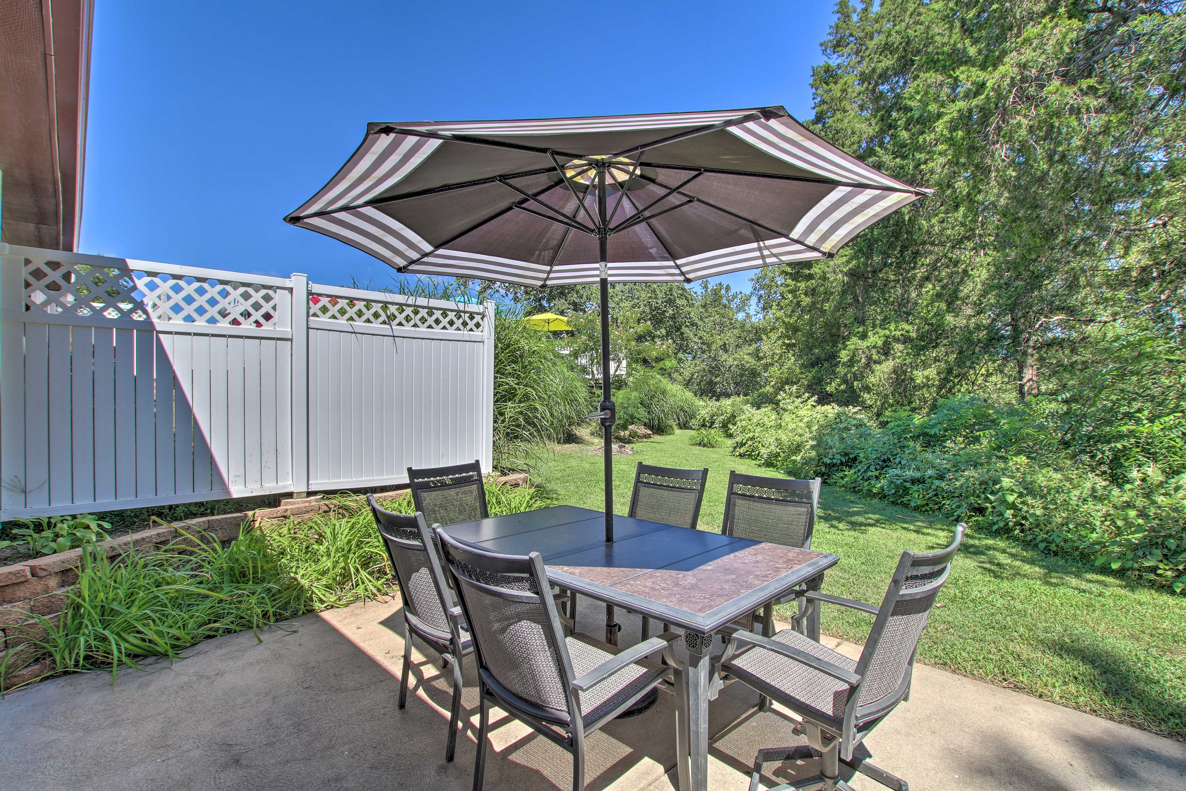 The umbrella provides shade, while the trees provide a serene backdrop.