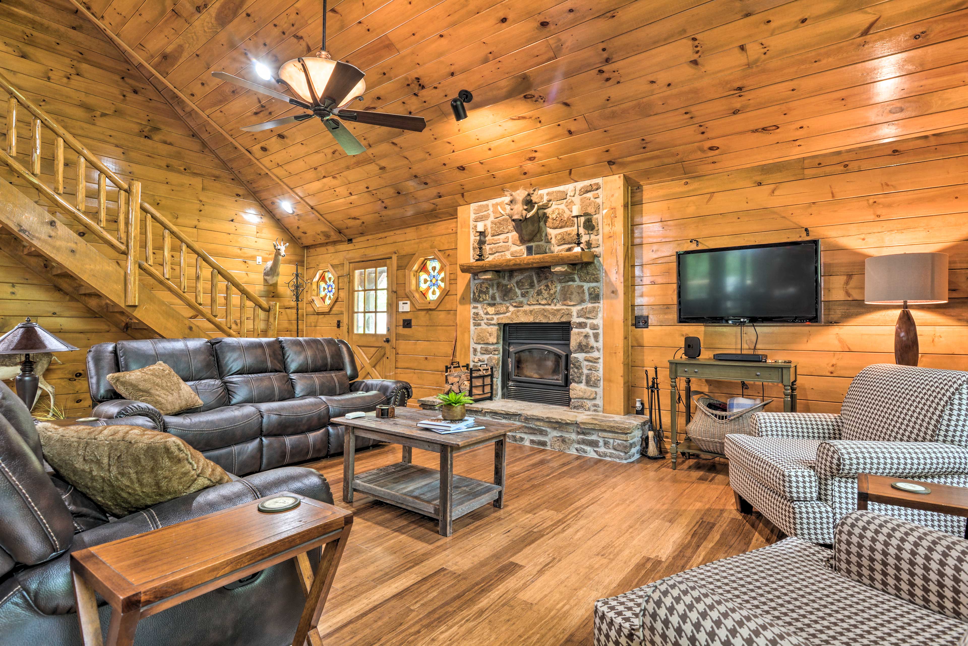 The home features many rustic accents like the stone fireplace & taxidermy.