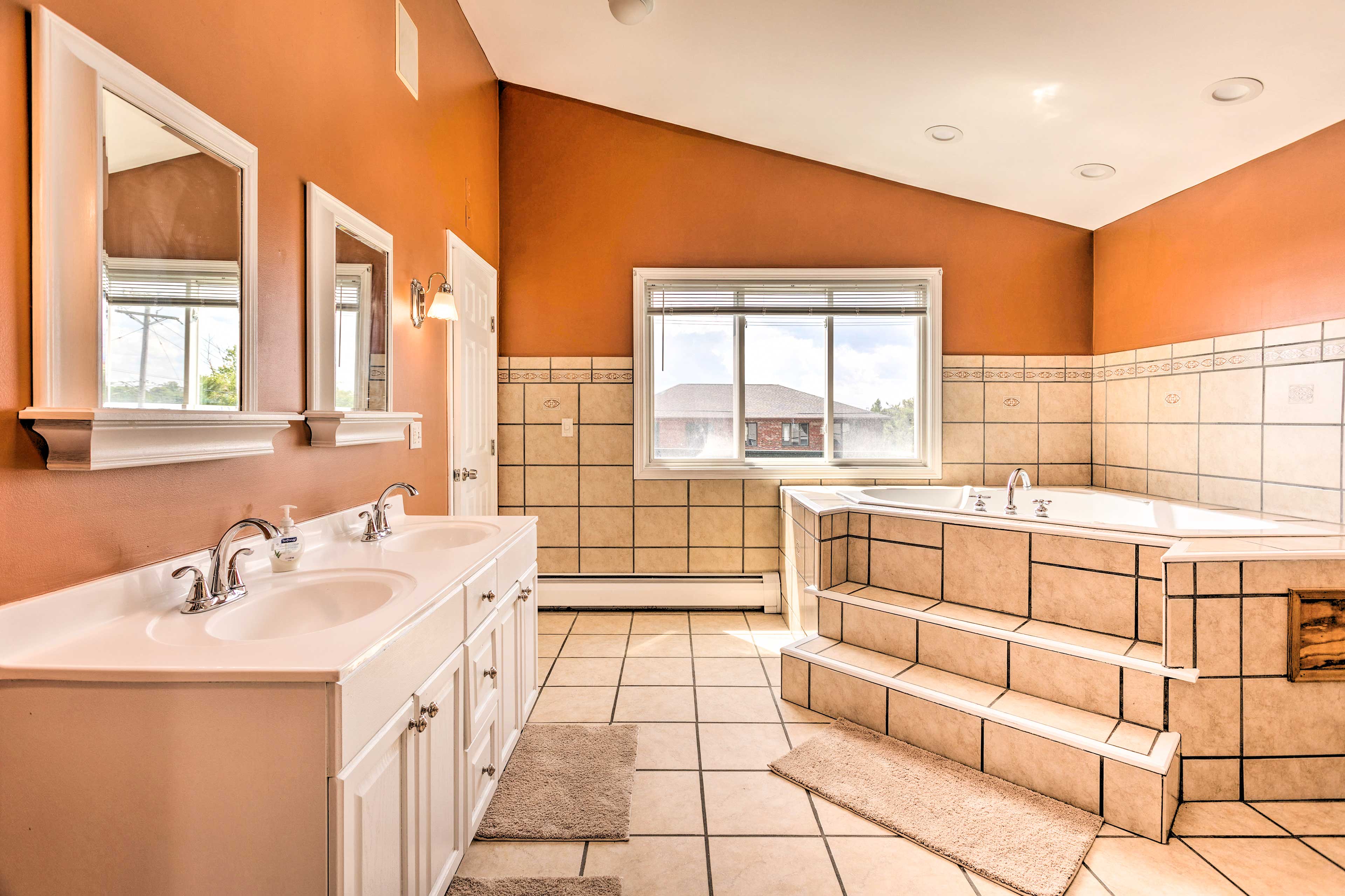 The master bathroom features dual-sink vanity and a soaking tub.