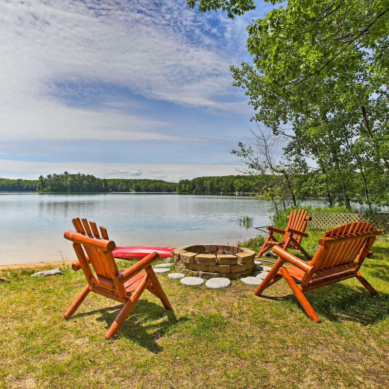 Adirondack chairs placed around an outdoor fire pit with views of Lake Michigan