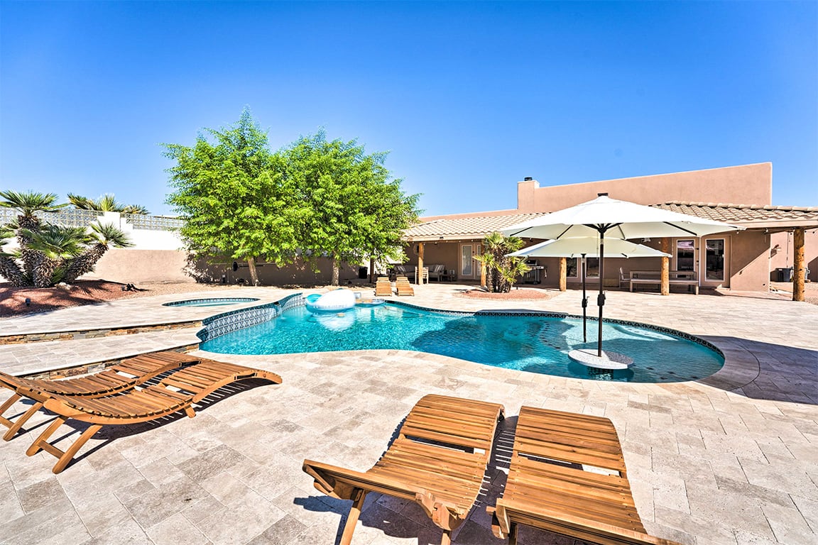 photo of a vacation home with a pool and lounge chairs