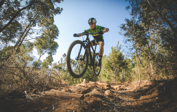 man in bike gear mountain biking intensely on a mountain